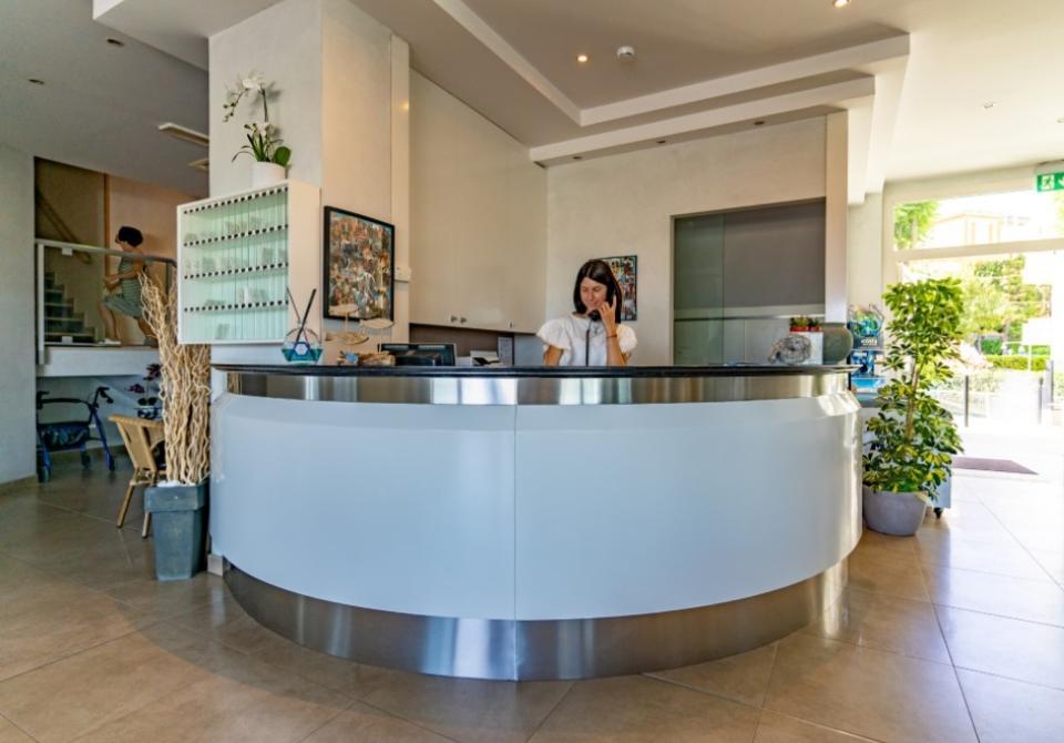 Reception moderna con arredamento minimalista e piante decorative.